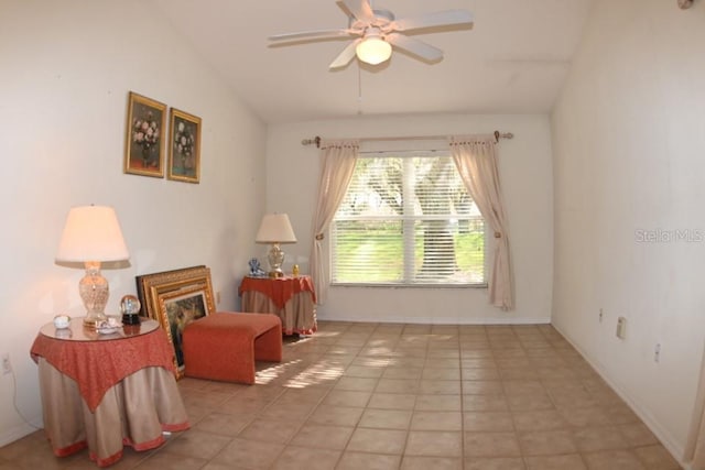 living area featuring light tile patterned floors, ceiling fan, baseboards, and vaulted ceiling