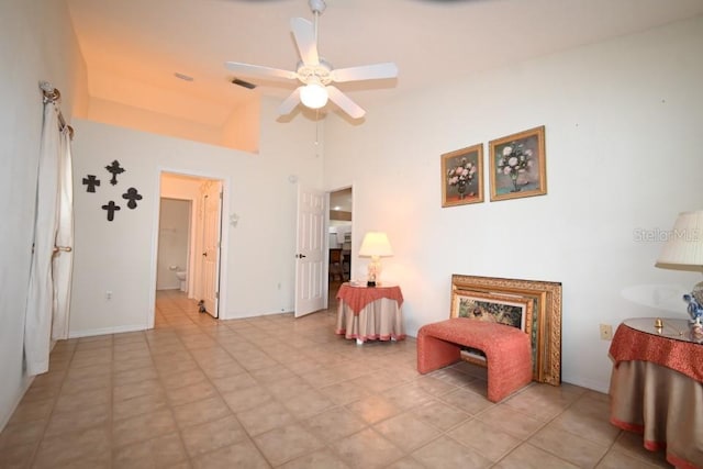 living area with high vaulted ceiling, visible vents, ceiling fan, and baseboards