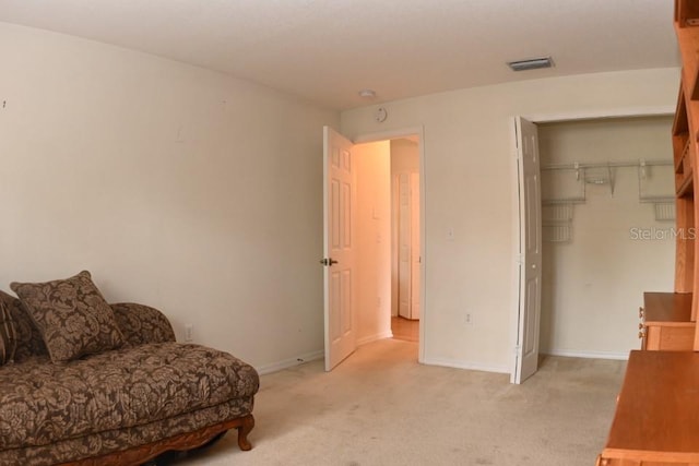 living area featuring baseboards, visible vents, and light colored carpet