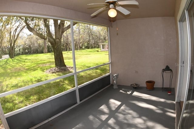 unfurnished sunroom with ceiling fan