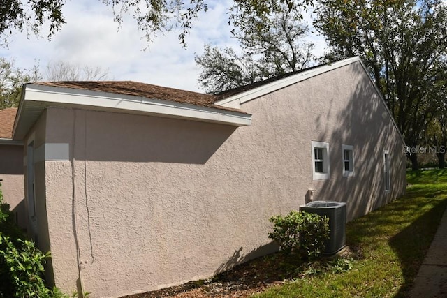 view of property exterior with central air condition unit and stucco siding