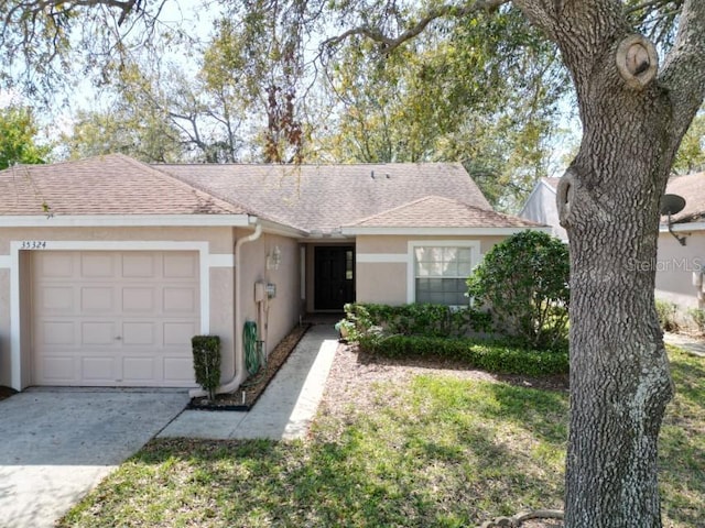 single story home with driveway, a shingled roof, an attached garage, and stucco siding