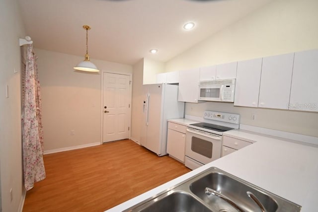 kitchen featuring pendant lighting, light wood finished floors, light countertops, vaulted ceiling, and white appliances