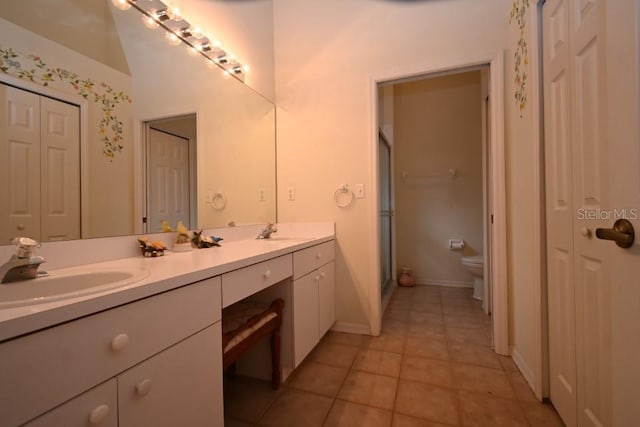 bathroom featuring double vanity, a closet, and a sink