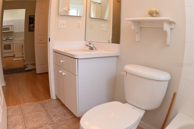 bathroom with vanity, toilet, and wood finished floors