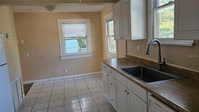 kitchen with dishwasher, white cabinetry, plenty of natural light, and sink