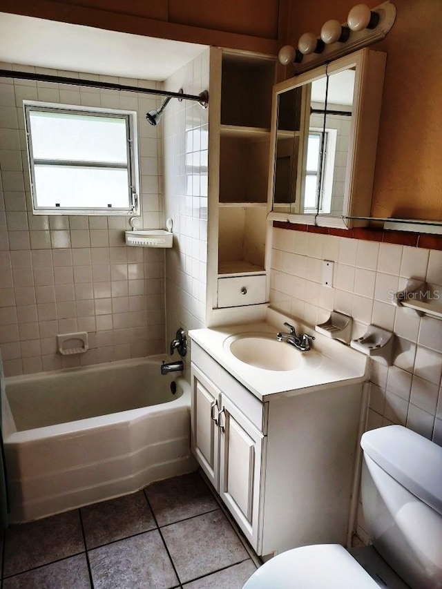 full bathroom with tiled shower / bath, vanity, toilet, and backsplash