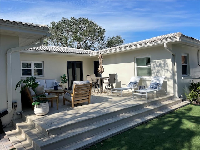 back of property featuring a deck and outdoor lounge area