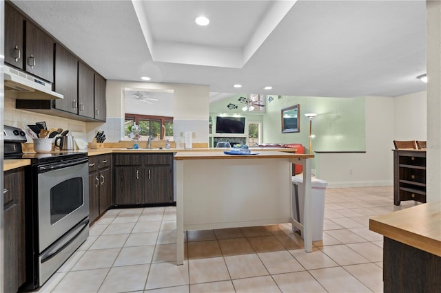 kitchen with dark brown cabinetry, stainless steel range with electric cooktop, decorative backsplash, sink, and ceiling fan