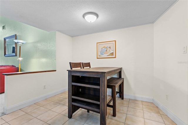 dining space with a textured ceiling and light tile patterned floors