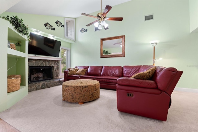 living room featuring ceiling fan, carpet flooring, a stone fireplace, and high vaulted ceiling