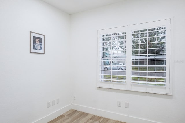 spare room with a wealth of natural light and hardwood / wood-style floors