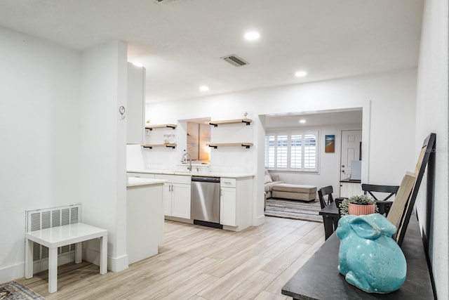 kitchen featuring sink, dishwasher, white cabinetry, and light hardwood / wood-style floors