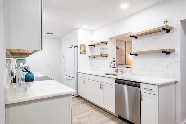 kitchen with dishwasher, sink, white refrigerator, white cabinets, and light wood-type flooring