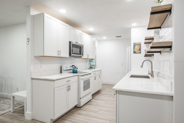 kitchen with white cabinets, decorative backsplash, sink, electric range, and light hardwood / wood-style flooring