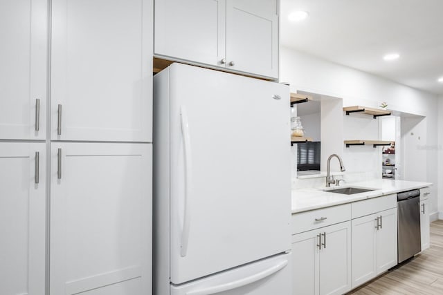 kitchen featuring dishwasher, white fridge, white cabinets, sink, and light hardwood / wood-style flooring