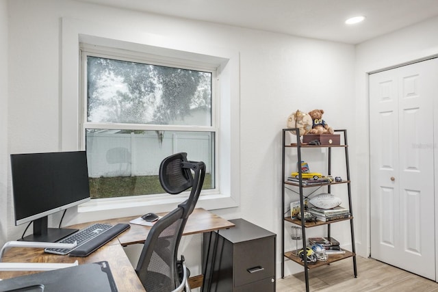 home office with light hardwood / wood-style flooring