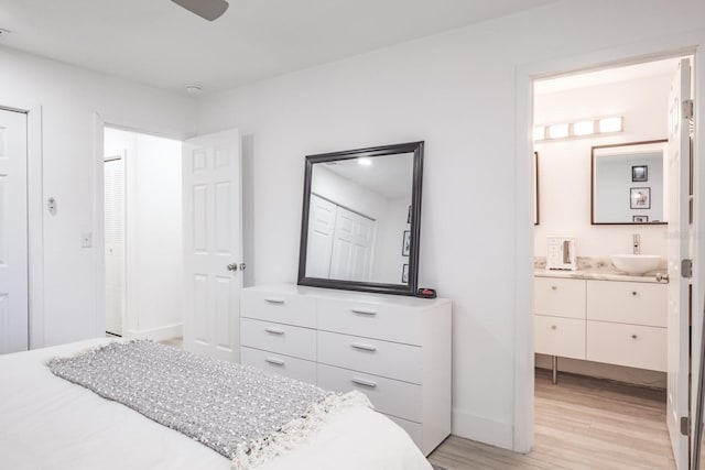 bedroom with sink, light hardwood / wood-style flooring, and ensuite bath