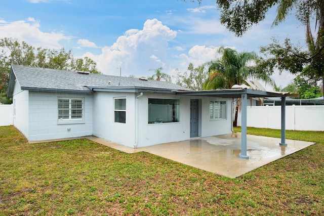 back of property with a patio area and a yard