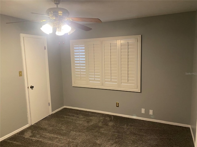 carpeted empty room featuring ceiling fan and baseboards