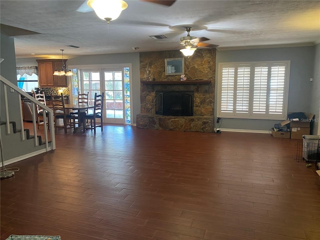 living room with dark wood-type flooring, a fireplace, visible vents, and baseboards