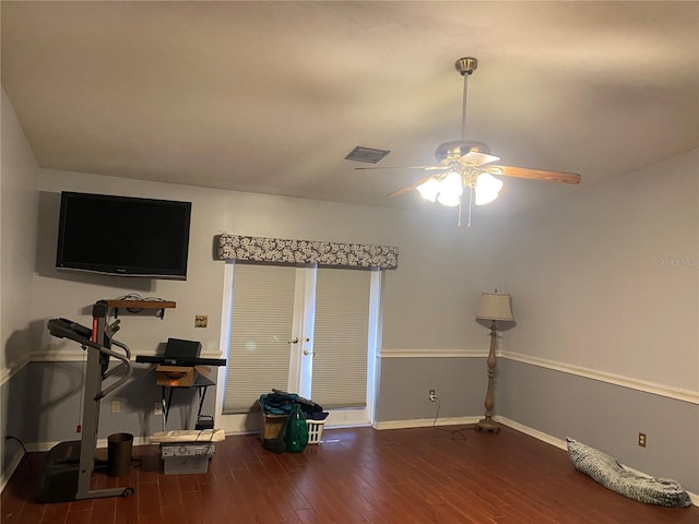 interior space featuring ceiling fan, wood finished floors, visible vents, and baseboards