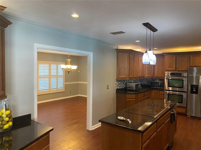 kitchen featuring appliances with stainless steel finishes, dark wood-style flooring, visible vents, and backsplash