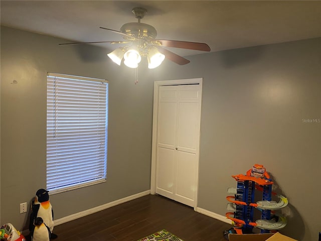 rec room with ceiling fan, dark wood-style flooring, and baseboards