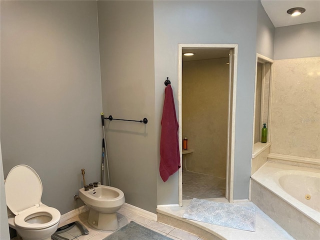 bathroom featuring baseboards, toilet, tile patterned floors, a jetted tub, and a bidet