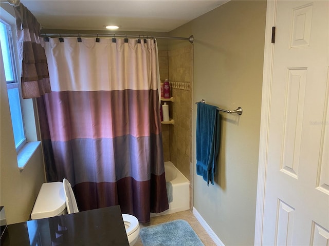 bathroom featuring toilet, tile patterned flooring, shower / bath combo, and baseboards