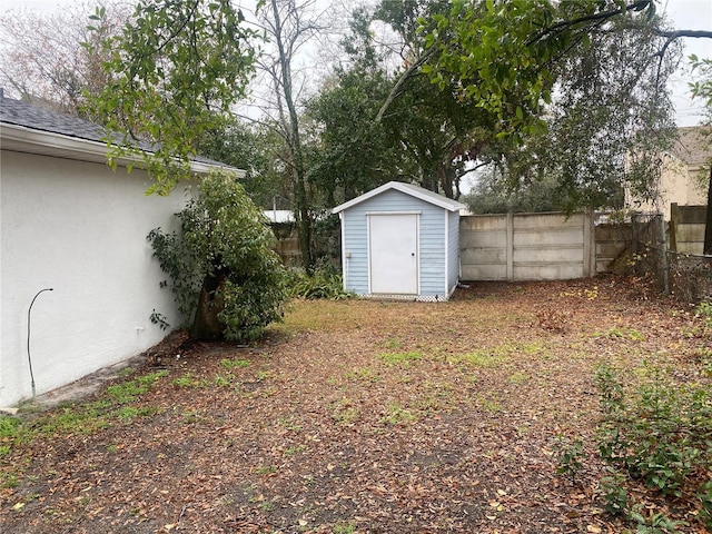 view of yard with a storage shed, an outdoor structure, and fence