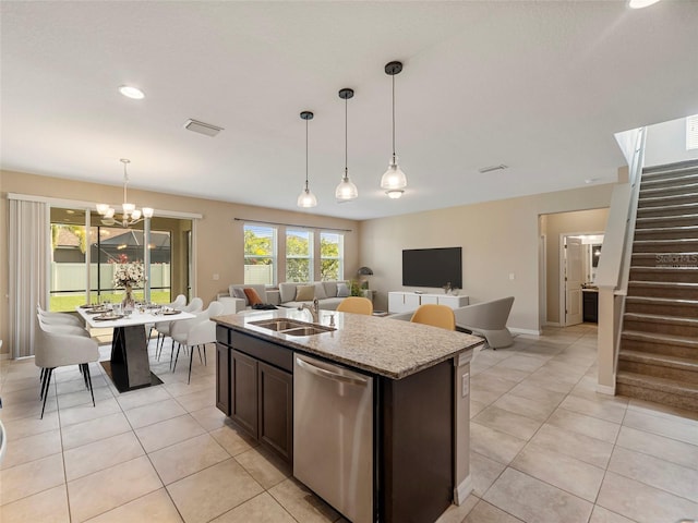 kitchen featuring dark brown cabinetry, dishwasher, an island with sink, sink, and hanging light fixtures