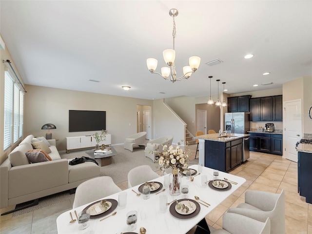 dining space with sink, light tile patterned floors, and a chandelier