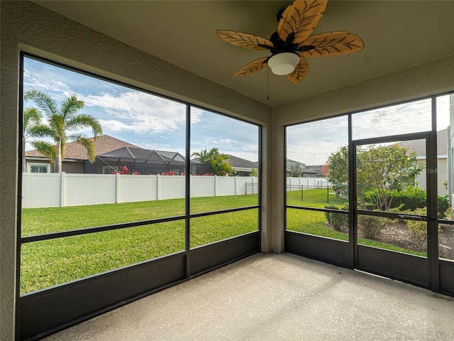 unfurnished sunroom with ceiling fan