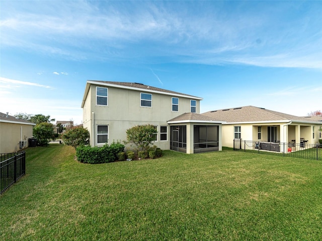 back of property featuring a sunroom and a lawn