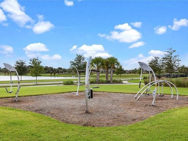 view of jungle gym with a water view and a lawn