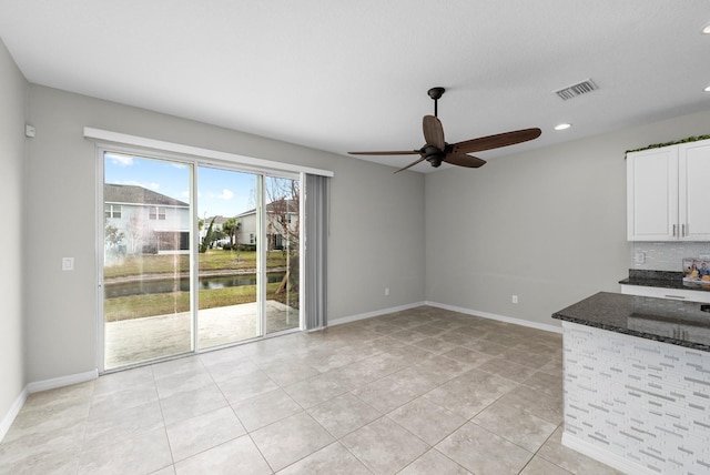 unfurnished living room featuring light tile patterned floors and ceiling fan