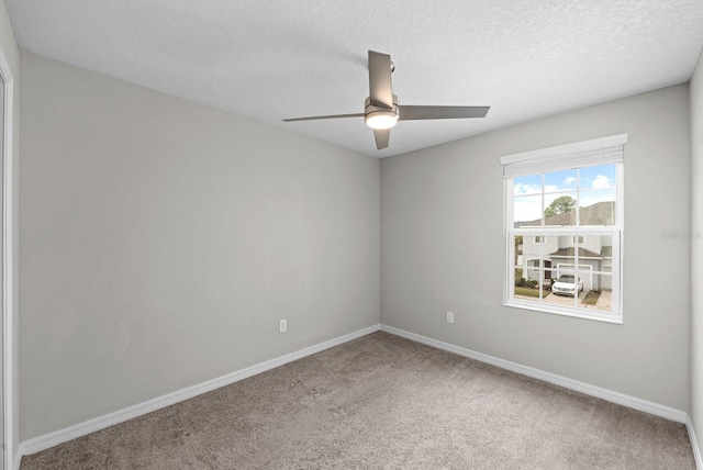 empty room featuring ceiling fan, a textured ceiling, and carpet floors