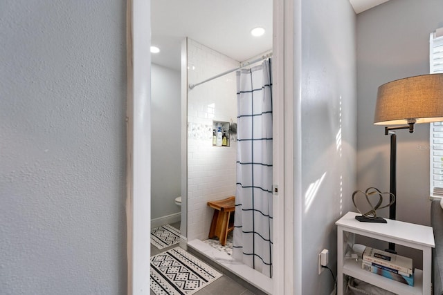 bathroom with toilet, a healthy amount of sunlight, tile patterned floors, and a shower with shower curtain