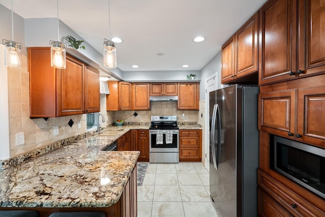 kitchen featuring hanging light fixtures, sink, light stone countertops, decorative backsplash, and stainless steel appliances