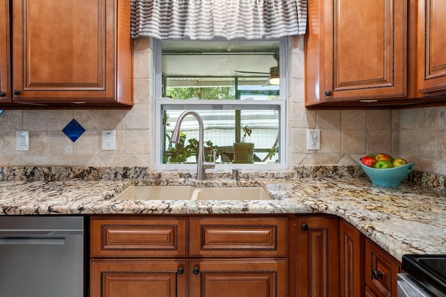 kitchen featuring sink, stainless steel dishwasher, tasteful backsplash, and light stone counters