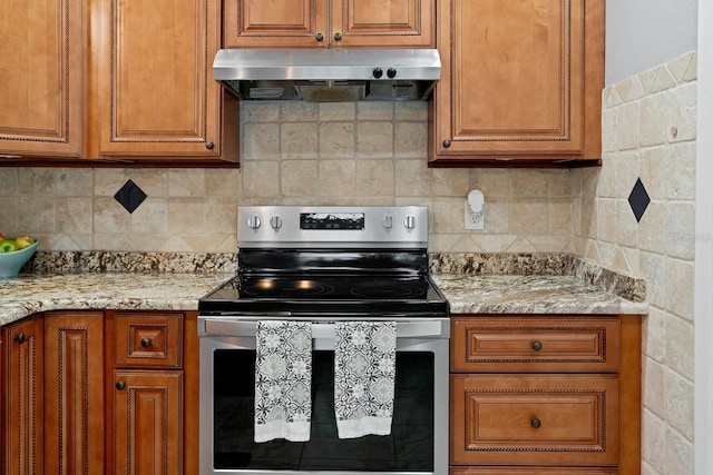 kitchen with backsplash, electric range, and light stone counters