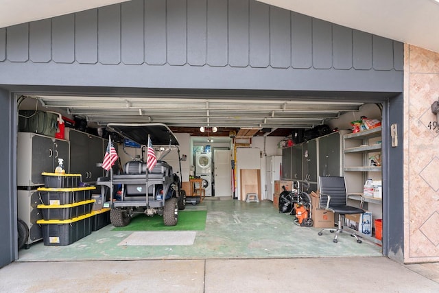 garage featuring refrigerator and stacked washer and dryer