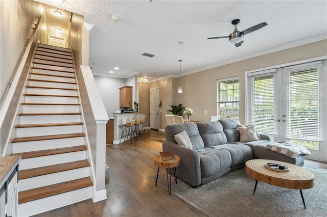 living room with ceiling fan, dark wood-type flooring, crown molding, and plenty of natural light