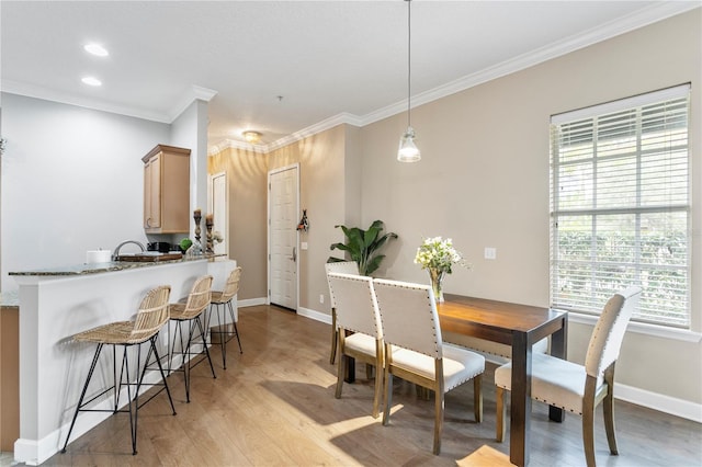 dining area featuring crown molding and light hardwood / wood-style floors