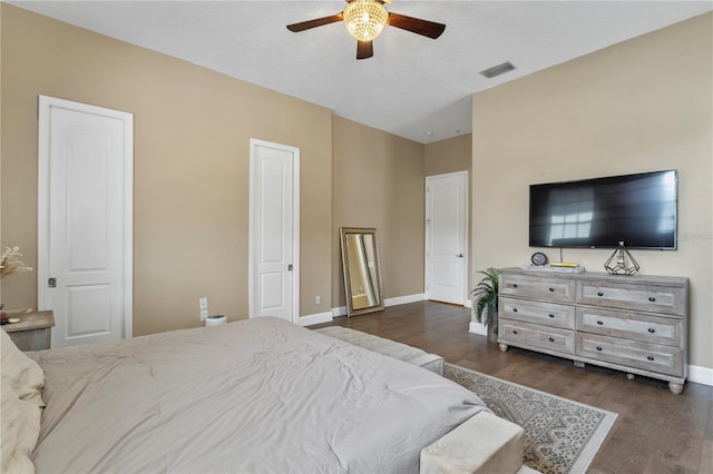 bedroom with ceiling fan, a textured ceiling, and dark hardwood / wood-style flooring