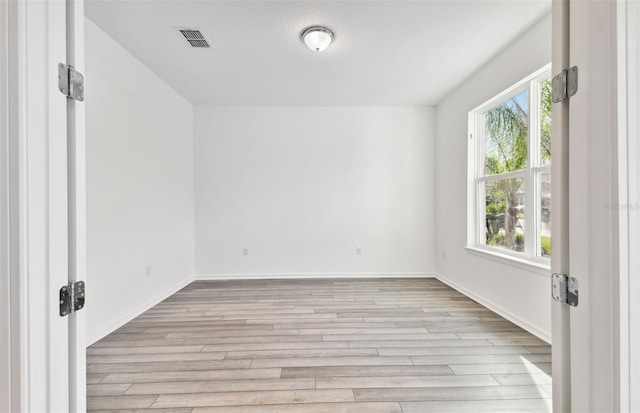 unfurnished room with a wealth of natural light and light wood-type flooring