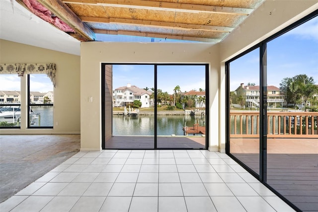 interior space with a water view and lofted ceiling with beams