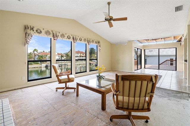 living room featuring ceiling fan, a water view, and vaulted ceiling