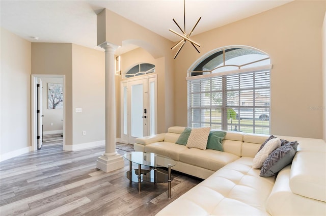 living room with decorative columns and light hardwood / wood-style floors